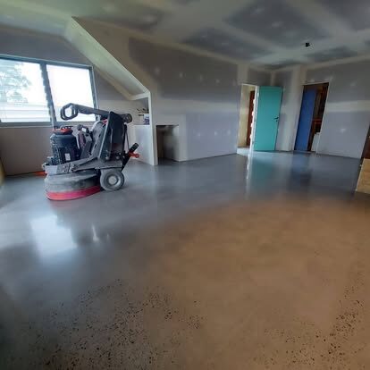 Planetary floor grinder cutting back a concrete slab mid-job on a Clark Concrete Polishing project