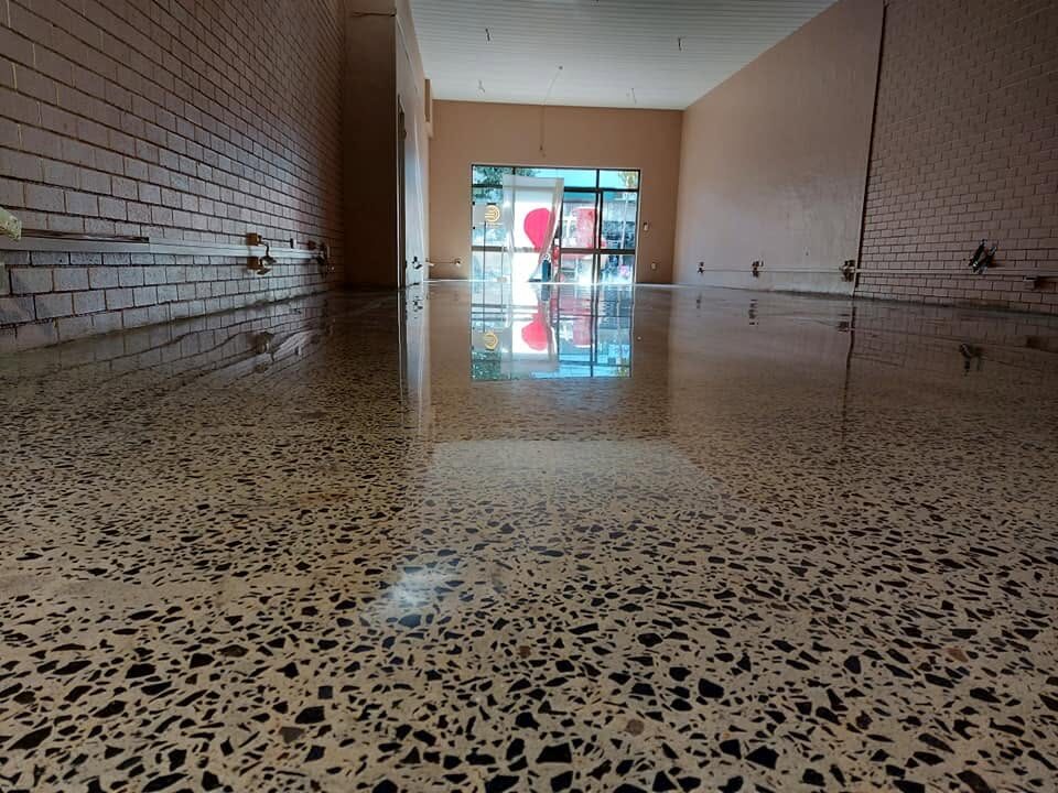 Mirror-gloss polished terrazzo floor reflecting a commercial storefront, an empty retail space in the Northern Rivers